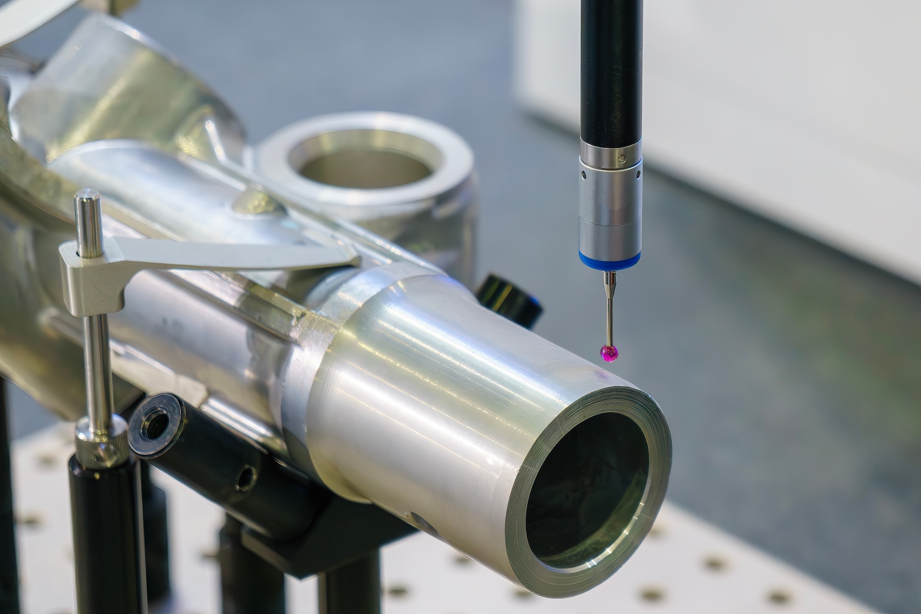 CMM inspection of a precision machined component using a touch probe for dimensional verification.